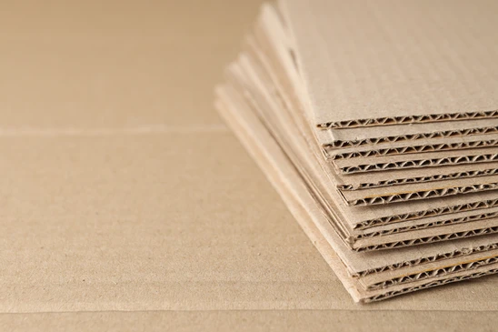 Emballages en carton kraft empil&eacute;s sur surface beige, mat&eacute;riaux d'exp&eacute;dition pour commerce &eacute;lectronique et logistique